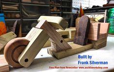 a wooden toy with wheels on it sitting on a table next to other woodworking tools