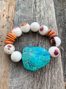 The Wailua bracelet is an absolute dream! This beach-chic bracelet includes a gorgeous blue-green Chrysocolla stone slab, paired with some of the oceans most spectacular treasures; fiery Spiny Oyster shell discs, and serene white Spiny Oyster shell beads with purplish markings. Filled with good vibes, these gemstones aid in promoting tranquility, serenity, peace, unconditional love, calmness, intimacy, subconscious wisdom, meditation, acceptance, tolerance, hope, and strength.  - One of a kind. You will receive this exact bracelet photographed - Approx. 1.75 inches length x 1.25 inches width Chrysocolla slab - 12mm Spiny Oyster shell discs - 12mm Spiny Oyster shell round beads - Strung on stretch memory cord Blue Natural Stones Bracelets For Beach, Blue Natural Stone Bracelets For Beach, Blue Natural Stone Beach Bracelets, Bohemian Oyster Bracelet For Vacation, White Bohemian Jewelry With Oyster Bracelet, White Gemstone Beads Bracelets For Beach, Turquoise Gemstone Beads Bracelets For Beach, Bohemian Hand-strung Stretch Bracelet For Vacation, Turquoise Bohemian Stretch Bracelet For Vacation