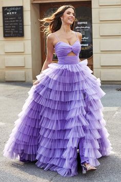 a woman in a purple dress is walking down the street