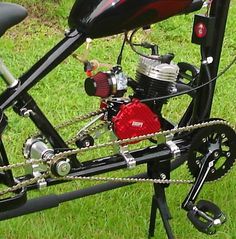 a black and red motorcycle parked on top of a lush green field