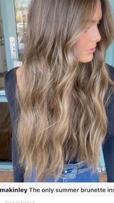 a woman with long, wavy hair standing in front of a store