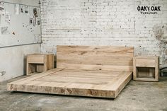 a bed made out of wood in front of a brick wall