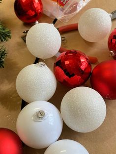 some white and red ornaments sitting on top of a table next to a pair of scissors