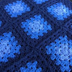 a crocheted blanket with blue and white flowers