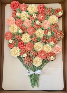 a bouquet of flowers made out of cupcakes in a box