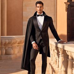 a man in a tuxedo standing on a balcony