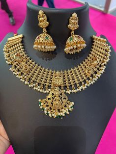 Gold South Necklace indian Pearl Antique jewelry set lakshmi goddess necklace set wedding jewelry set temple jewellery set red green stone The set includes 2 necklace and a pair of earrings  This handmade designer crescent design m statement antique gold plated is studded with lakshmi motifs, kemp stones and white pearls. This south indian jewelry can be worn for wedding and festive occasions paired with traditional outfits like saree and lehenga. Temple Jewelry enhances the look of the sarees, Luxury Traditional Temple Necklace For Reception, Luxury Gold Temple Necklace For Reception, Luxury Traditional Temple Necklace With Cutdana, Luxury Round Temple Necklace For Festive Occasions, Luxury Temple Necklace For Anniversary And Festivals, Luxury Temple Necklace With Stone Work For Celebration, Luxury Temple Necklace For Reception During Diwali, Luxury Temple Jewelry, Luxury Heavy Fusion Temple Necklace