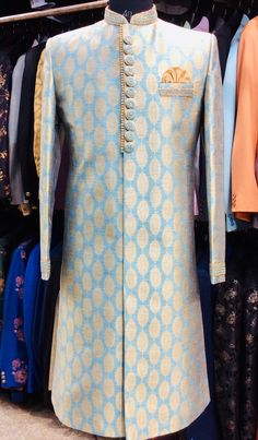 Item Contains:  Sherwani and pyjama Fabrics :   Banarsi brocade silk  Colours :  Peacock blue and golden Style and Designs :  Sherwani has mandarin collar and long sleeves with a full button placket symmetric hem and multiple slits it has embroidered collar button and sleeves edges with same coloured beads zari and resham thread  Pants :  Slim fit Traditional Churidar Pants Made of Raw Silk Nara Clousure Style  Size :  Slim fit  Model height is 6 fitt and wearing 40 size  Material and Care :  Ra Dabka Embroidered Sherwani For Groom At Eid, Anarkali Style Jamawar Sherwani For Festivals, Wedding Sherwani With Dabka Work, Straight Kurta, Dabka Detailed Sherwani For Groom At Eid, Ceremonial Anarkali Sherwani For Festivals, Sherwani With Naqshi On Jamawar Fabric, Anarkali Sherwani With Pallu For Festivals, Festival Anarkali Style Jamawar Sherwani, Festival Anarkali Sherwani With Pallu