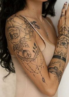 a woman with long black hair and tattoos on her arms