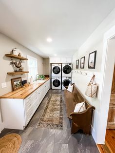 a kitchen with an oven, washer and dryer next to a long counter