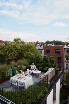 two people sitting at a table on top of a roof