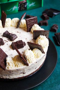 a cake with white frosting and chocolate pieces