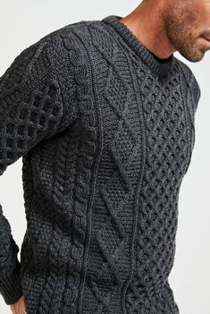 Named Éireann, after the landscape and country that inspired its creation. The Éireann is the quintessential Aran sweater, for him and for her. A proud member of the Supersoft Collection, this piece balances Irish Authenticity with modern comfort, uncompromising in quality and heart. With a stunning combination of traditional Aran stitches such as honeycomb, moss and cable, this piece holds the power of Ireland’s rich history while simultaneously standing tall as a contemporary, versatile additi Aran Stitches, Irish Wool Sweater, Irish Wool Sweaters, Crochet Men, Aran Sweater, Irish Men, Mens Winter Fashion, Yarn Shop, Pullover Men