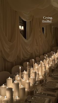 a long table with many lit candles on it