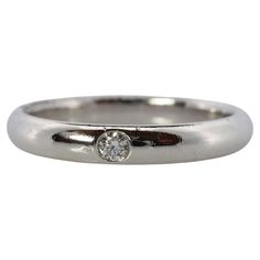 a white gold ring with a single diamond