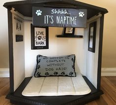 the dog bed is made out of an old wooden structure with black and white decor