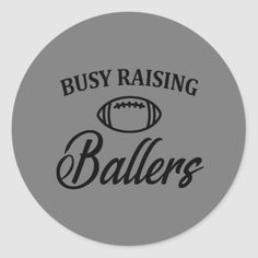 a grey sticker with the words busy raising ballers in black letters on it