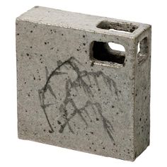 a cement block with graffiti on it and a hole in the middle that has been cut open