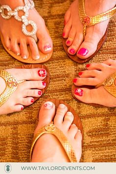 four women's feet with different colored nail polishes and gold sandals on the floor