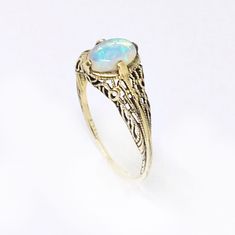 This is a solid 14k yellow gold ring with a beautiful natural crystal opal prong set in a Victorian ring setting. The oval opal cabochon is 6 x 4mm and has bright flashes of green, blue and orange fire. The type of opal is a solid Australian opal that is named crystal opal because of its crystal like transparency. The ring setting is a reproduction of a Victorian ring that has fine filigree details. Custom made to order. Please message me if you would like to choose the opal or a different gemst Opal Gold Ring, 14k Gold Opal Ring, Dinosaur Ring, Victorian Style Rings, Australian Opal Ring, Natural Opal Ring, Victorian Ring, Opal Ring Gold, Crystal Opal