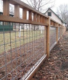 the fence is made of wood and metal wire, along with leaves on the ground