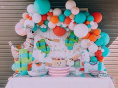 a table topped with lots of balloons and cake