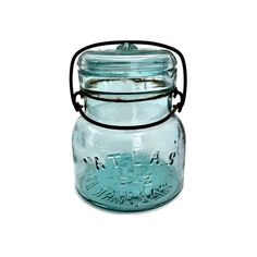 a glass jar with a metal handle on a white background