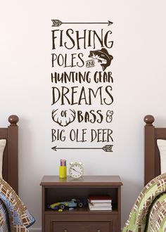 two beds in a room with a wall sticker on the wall above them that says fishing poles and humming gear dreams & bass's big olee deer