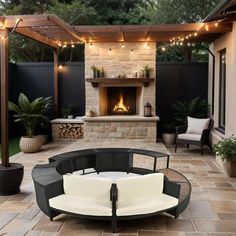 an outdoor fireplace and seating area with lights