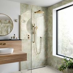 a bathroom with a sink, mirror and shower head in the corner next to a window