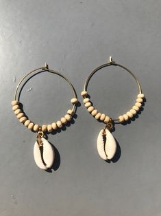 Cowrie Shell Hoop Earrings! ★ SOLD as a PAIR ★ Material - Stainless Steel Hoop (in Plain Steel or with 18K Gold Plating) - Hypoallergenic, Low Reactivity, Resistant to Tarnish & Excellent Durability - Wood Beads - Natural Cowrie Shell ★ Measurements - 40 mm Hoop PLEASE NOTE - Be aware that the actual product might have slight variations in colour. This is due to the light and monitor resolution. - Shipping time can take longer (it depends on shipping company & customs) - If you prefer a Handmade Hoop Jewelry For The Beach, Handmade Hoop Earrings For The Beach, Adjustable Pierced Hoop Earrings, Hoop Earrings For Beach With Pierced Ears, Handmade Round Hoop Earrings For Beach, Beach Hoop Earrings Wire Wrapped, Beach Wire Wrapped Hoop Earrings, Beach Hoop Earrings With Wire Wrapping, Minimalist Handmade Earrings For Beach