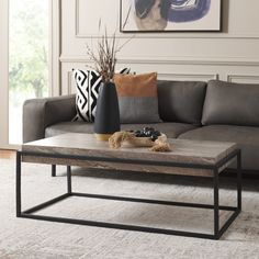 a living room with a couch, coffee table and pictures on the wall