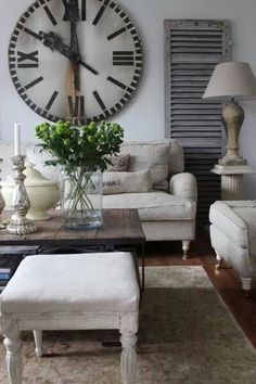 a living room filled with furniture and a large clock on the wall