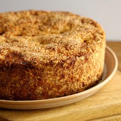 a cake sitting on top of a wooden cutting board next to a knife and fork