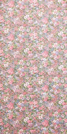 a pink and blue flowered fabric with small flowers on it's side,