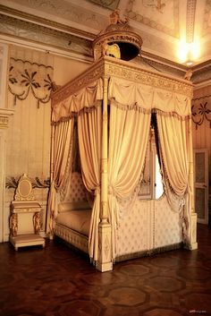 an ornate canopy bed in the middle of a room