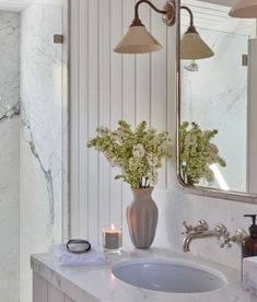 a bathroom with marble counter tops and white walls