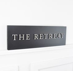 a sign that says the retreat on it's side in front of a door