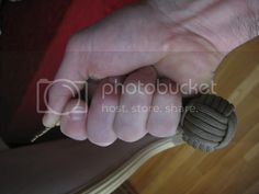 a person holding something in their hand on top of a wooden floor