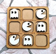 a wooden board with cut out faces and words on it, in the shape of ghost heads