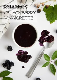 a bowl of blueberry sauce next to berries and leaves