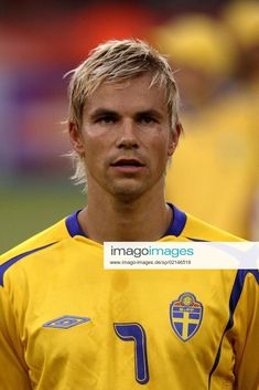 a soccer player with blonde hair is looking at the camera while wearing a yellow uniform