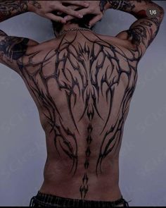 the back of a man with tattoos on his upper and lower body is covered in vines