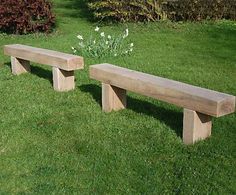 two wooden benches sitting on top of a lush green field