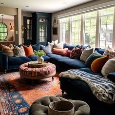 a living room filled with blue couches and pillows on top of a colorful rug