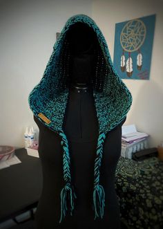 a mannequin wearing a blue and green shawl with beads on it's head