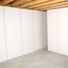 an empty room with white walls and wood beams