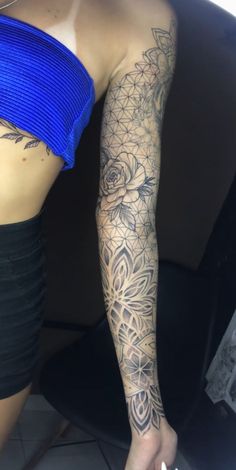 a woman's arm with tattoos on it and a flower tattoo on the side