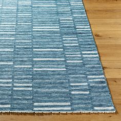 a blue and white rug on wooden floors