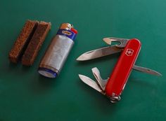 a swiss army knife, corkscrew and lighter on a green surface